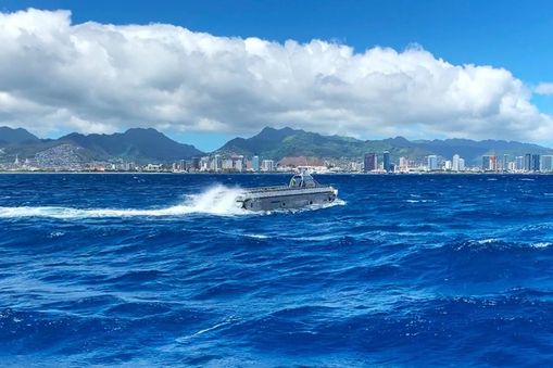 Boat driving through ocean with Hawaii in background — Applied CAx Siemens defense maritime software