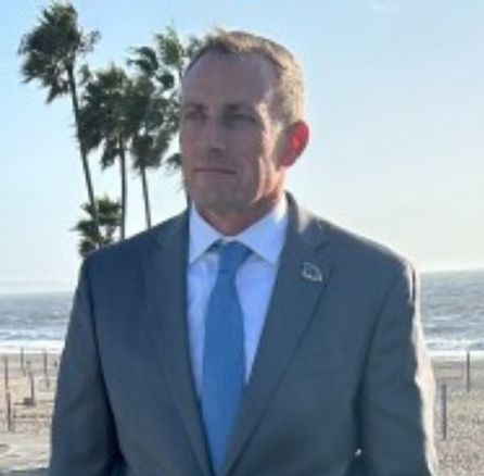 Man on a beach in a suit smiling for a headshot - Applied CAx Siemens software