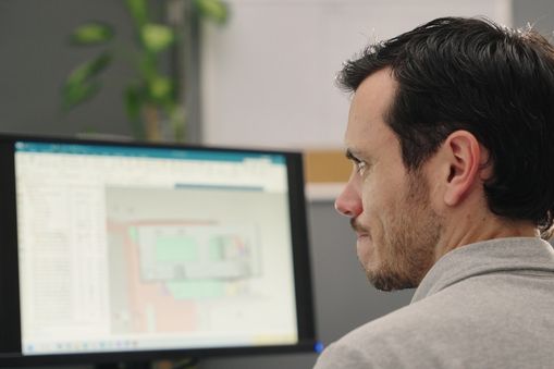 Man looking at a computer screen with NX CAD on the screen - Applied CAx Siemens NX software